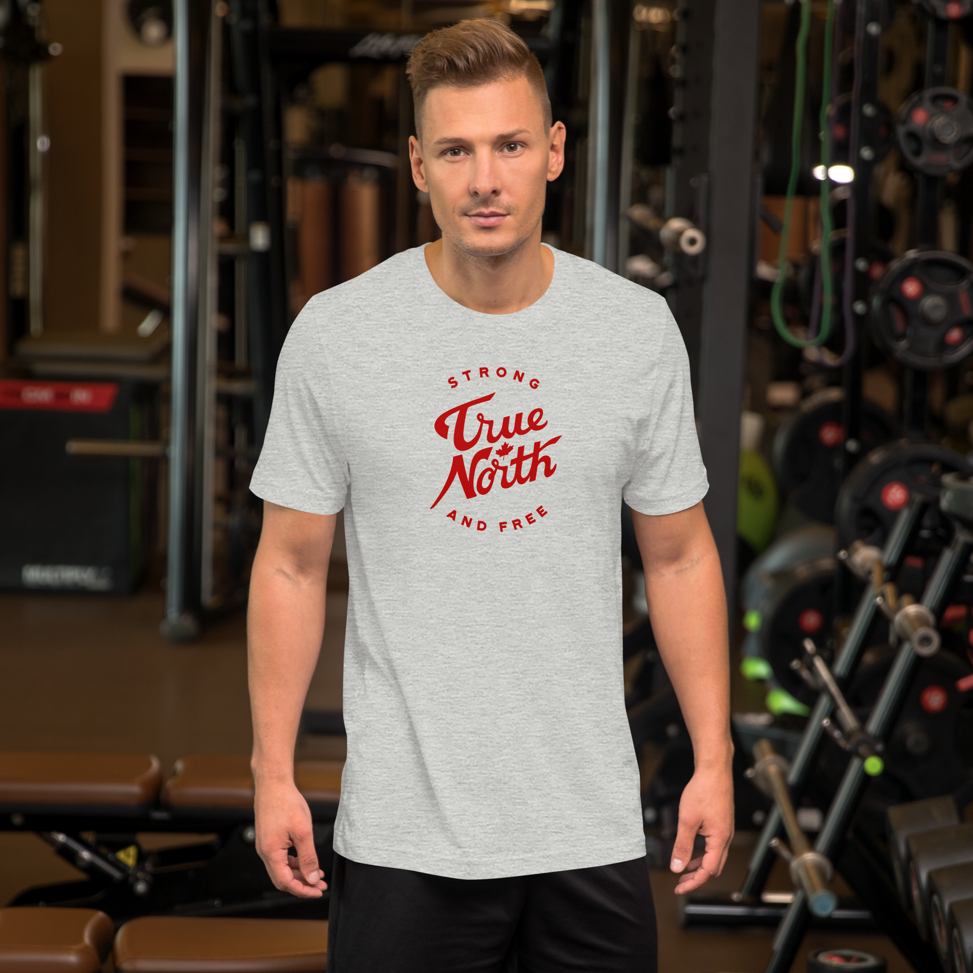 Man wearing a grey t-shirt with 'True North Strong and Free' text in a gym setting