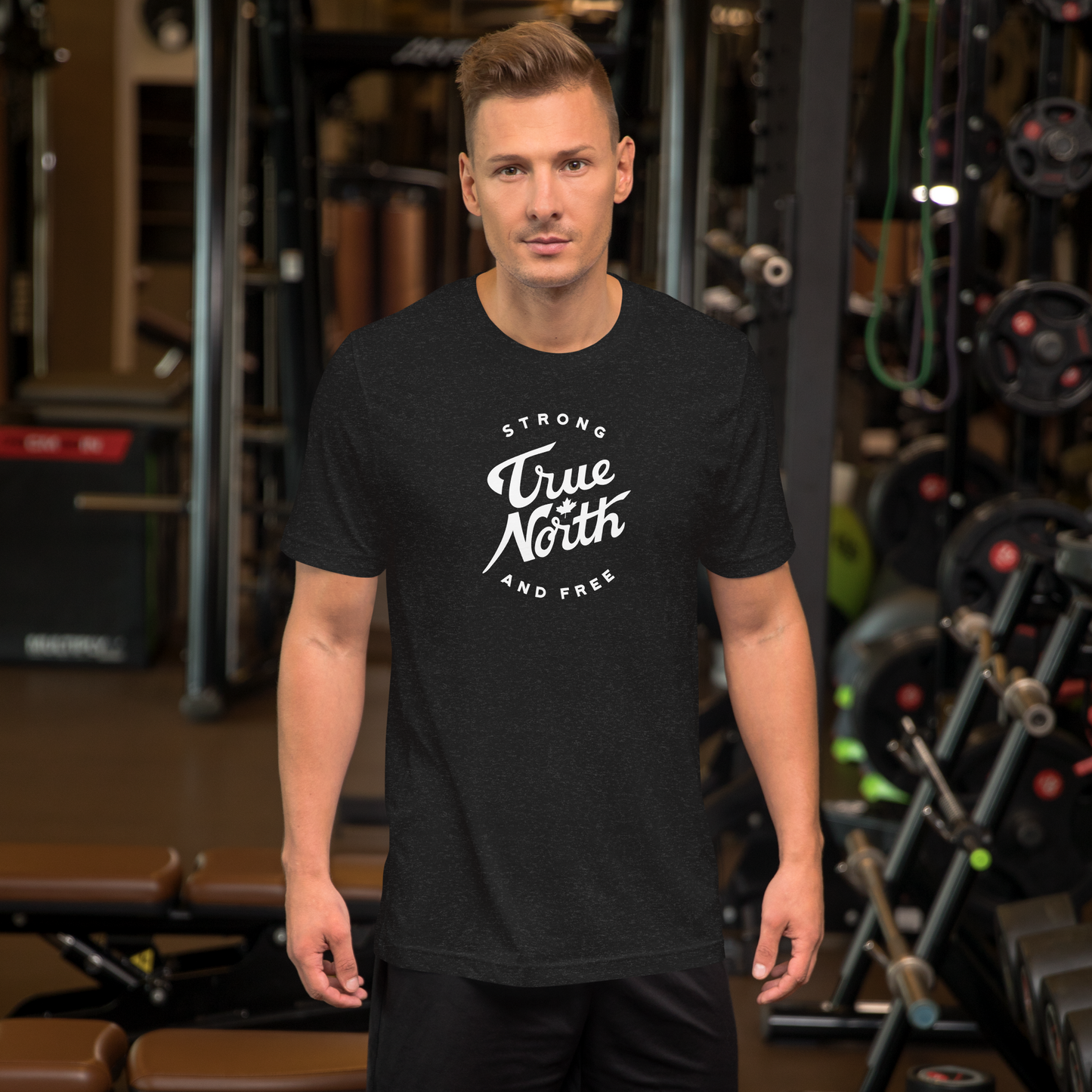 Man wearing a black t-shirt with 'True North Strong and Free' text in a gym setting