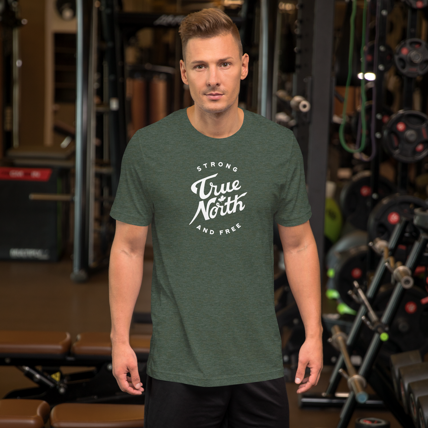 Man wearing a green t-shirt with 'True North Strong and Free' text in a gym setting